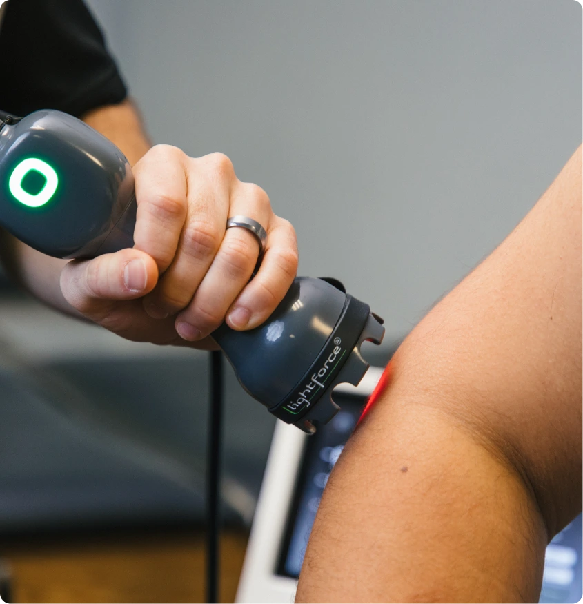 Practitioner applying Class IV laser therapy device to patient's shoulder