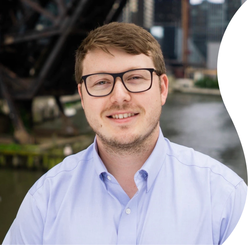 Doctor wearing glasses and light blue shirt, outdoor urban background