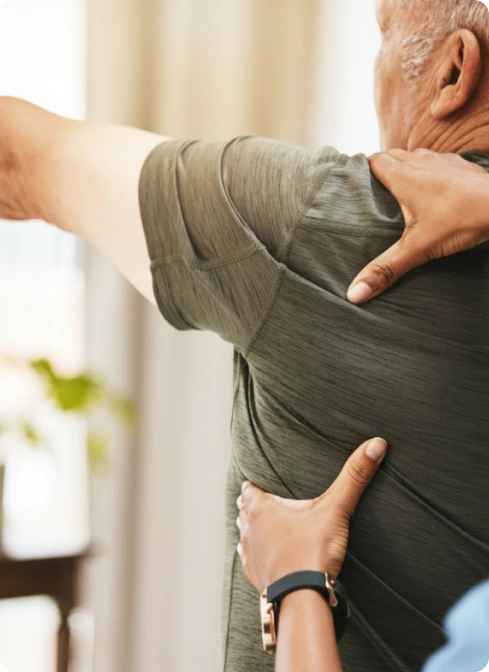Practitioner palpating patient's upper back and shoulder area