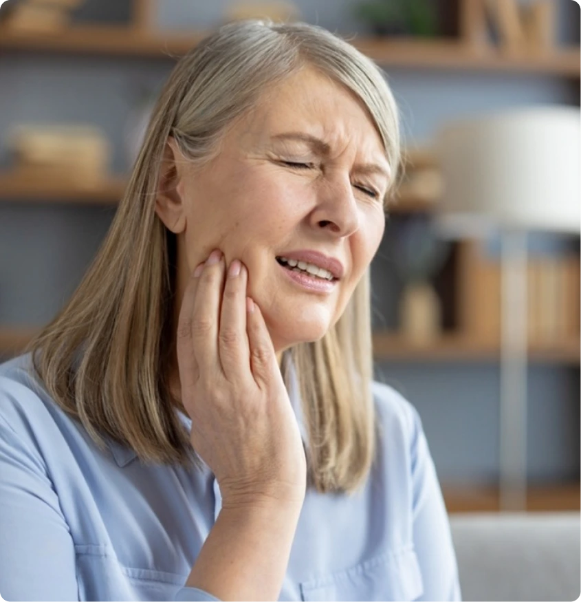 Woman holding her jaw, showing signs of TMJ discomfort