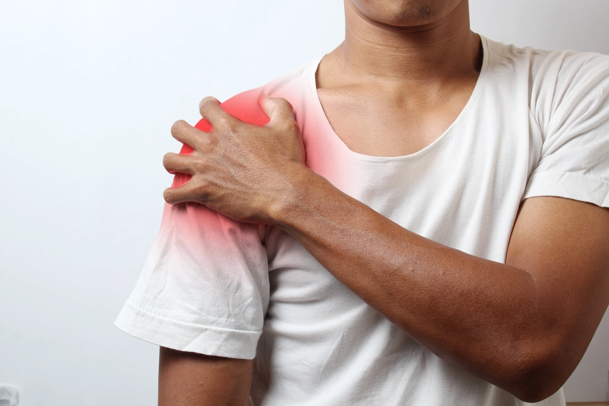 Man holding shoulder with red pain overlay indicating shoulder and neck pain